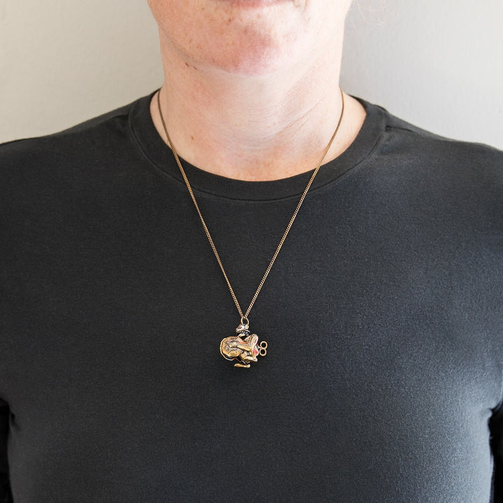 Model wearing Arcane × RockLove Jinx Monkey necklace at collarbone length.