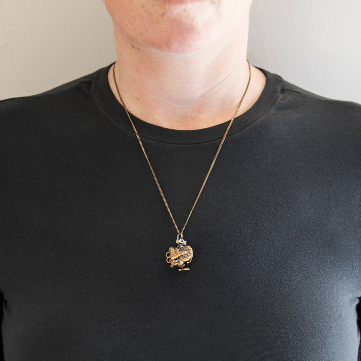 Close-up of model wearing Arcane × RockLove Jinx Monkey necklace on bronze chain.